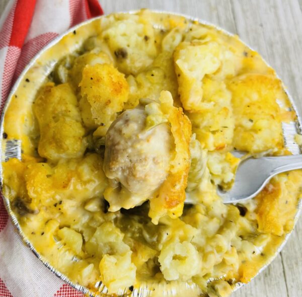 A bowl of food with some meat and potatoes