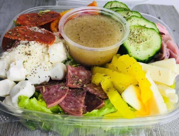 A salad with meat, cheese and vegetables in it.