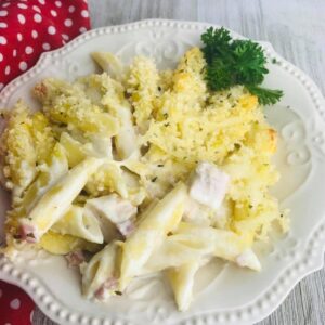 A white plate topped with macaroni and cheese covered in sauce.