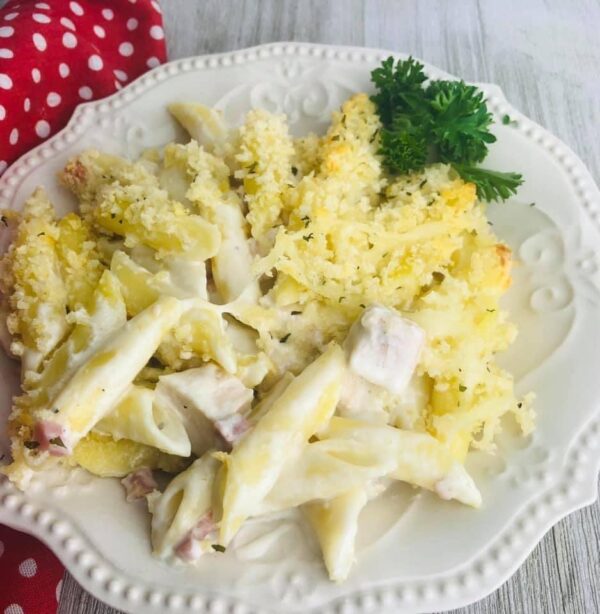 A white plate topped with macaroni and cheese covered in sauce.