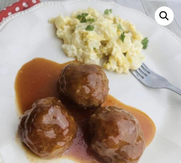 A plate of meatballs and mashed potatoes with gravy.