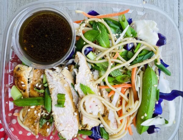 A plate of food with noodles, meat and vegetables.