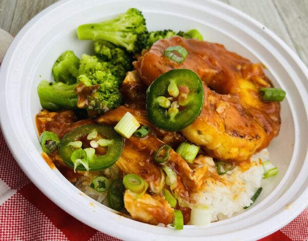 A bowl of food with broccoli and jalapenos.