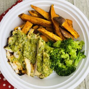 A white plate topped with chicken, broccoli and sweet potato.
