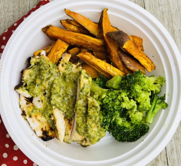A white plate topped with chicken, broccoli and sweet potato.