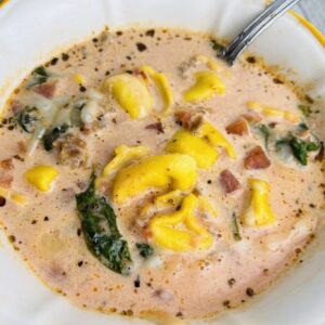 A bowl of soup with ham and cheese.