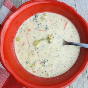 A bowl of soup with broccoli and carrots.